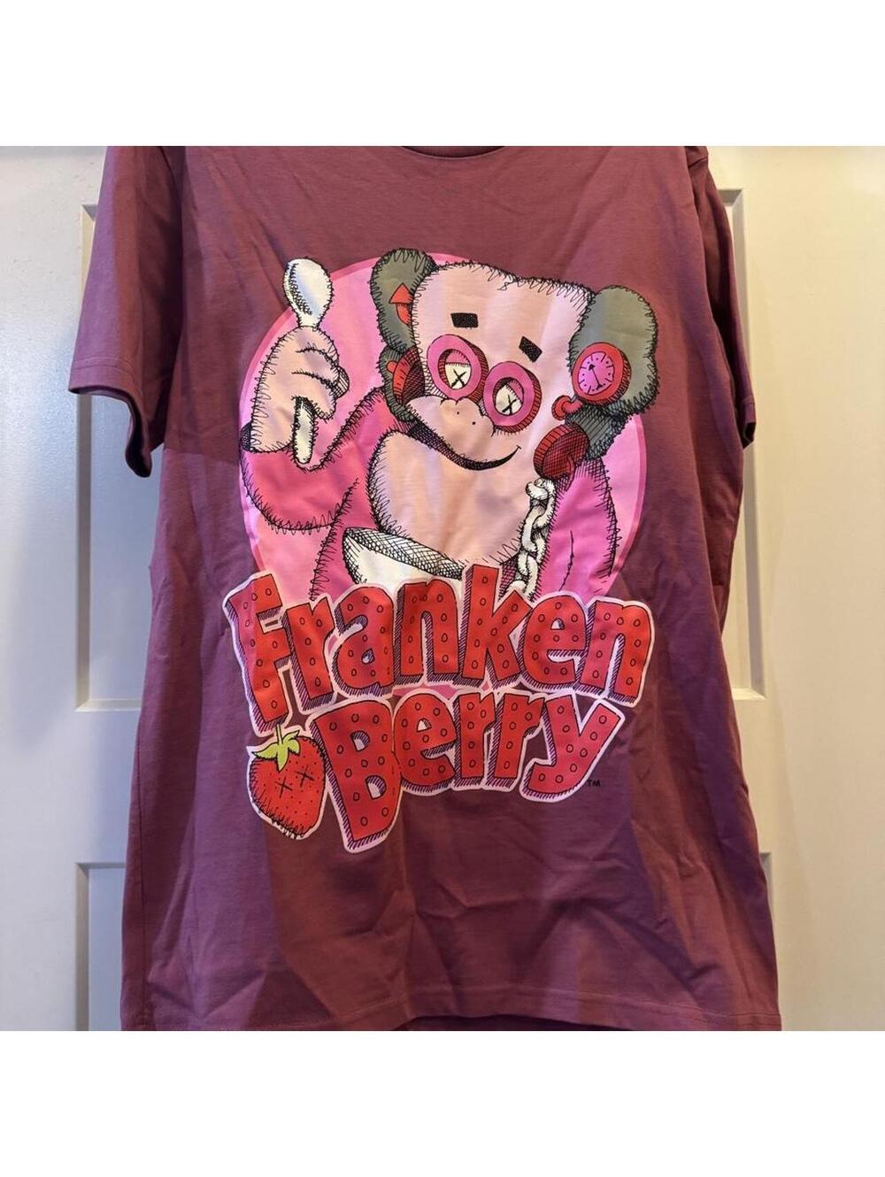 KAWS Frankenstein Berry General Mills burgundy cotton t-shirt with pink accents.